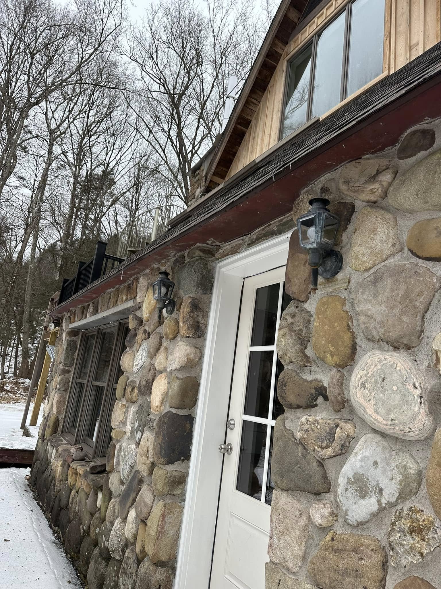 Stone veneer exterior siding accent combined with traditional siding materials.